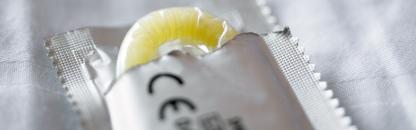Kondom ragt aus aufgerissener Verpackung Die kassenfinanzierte Verhütung sollte auch Kondome umfassen